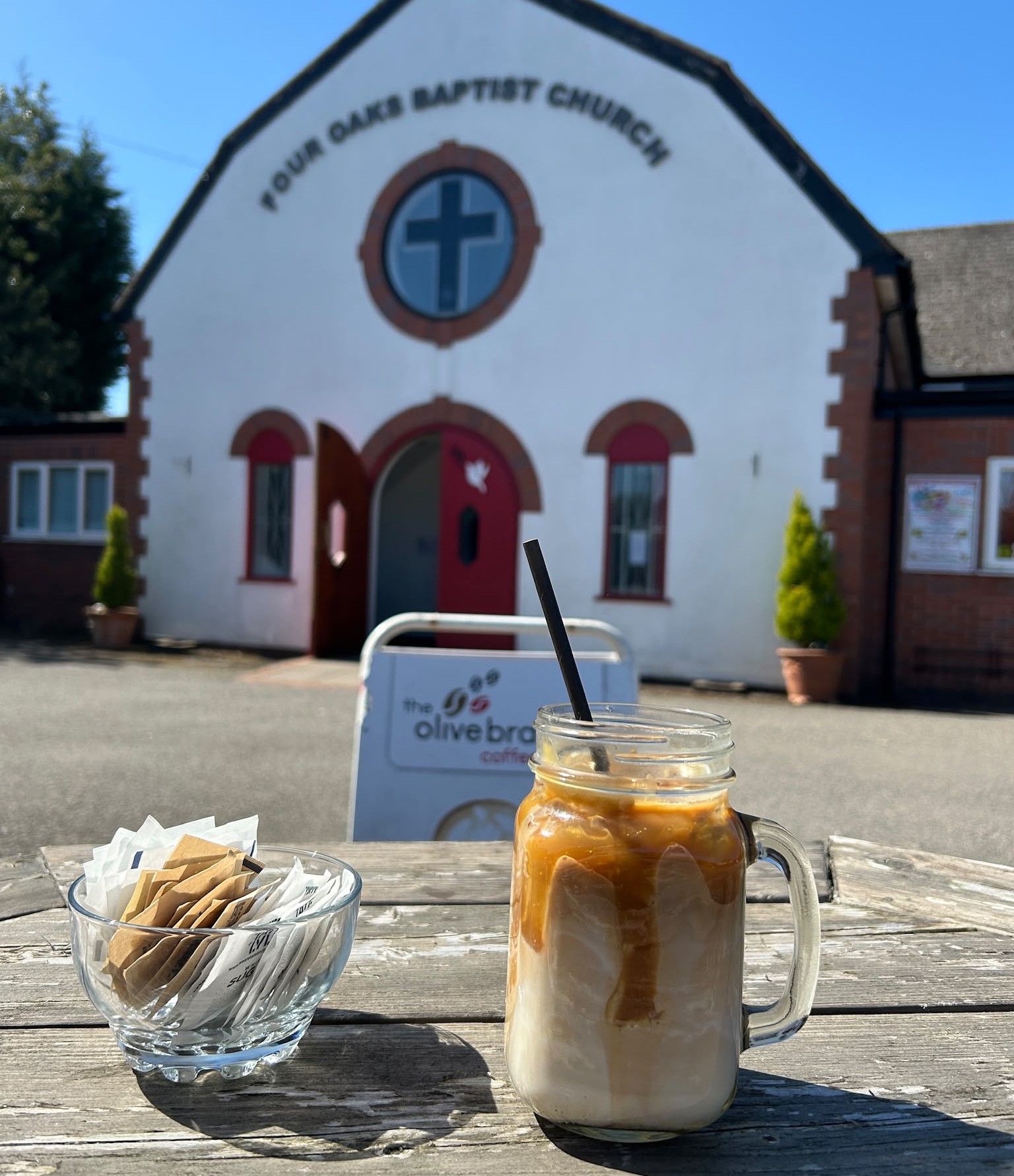 Iced coffee on a picnic table outside Four Oaks Baptist Church