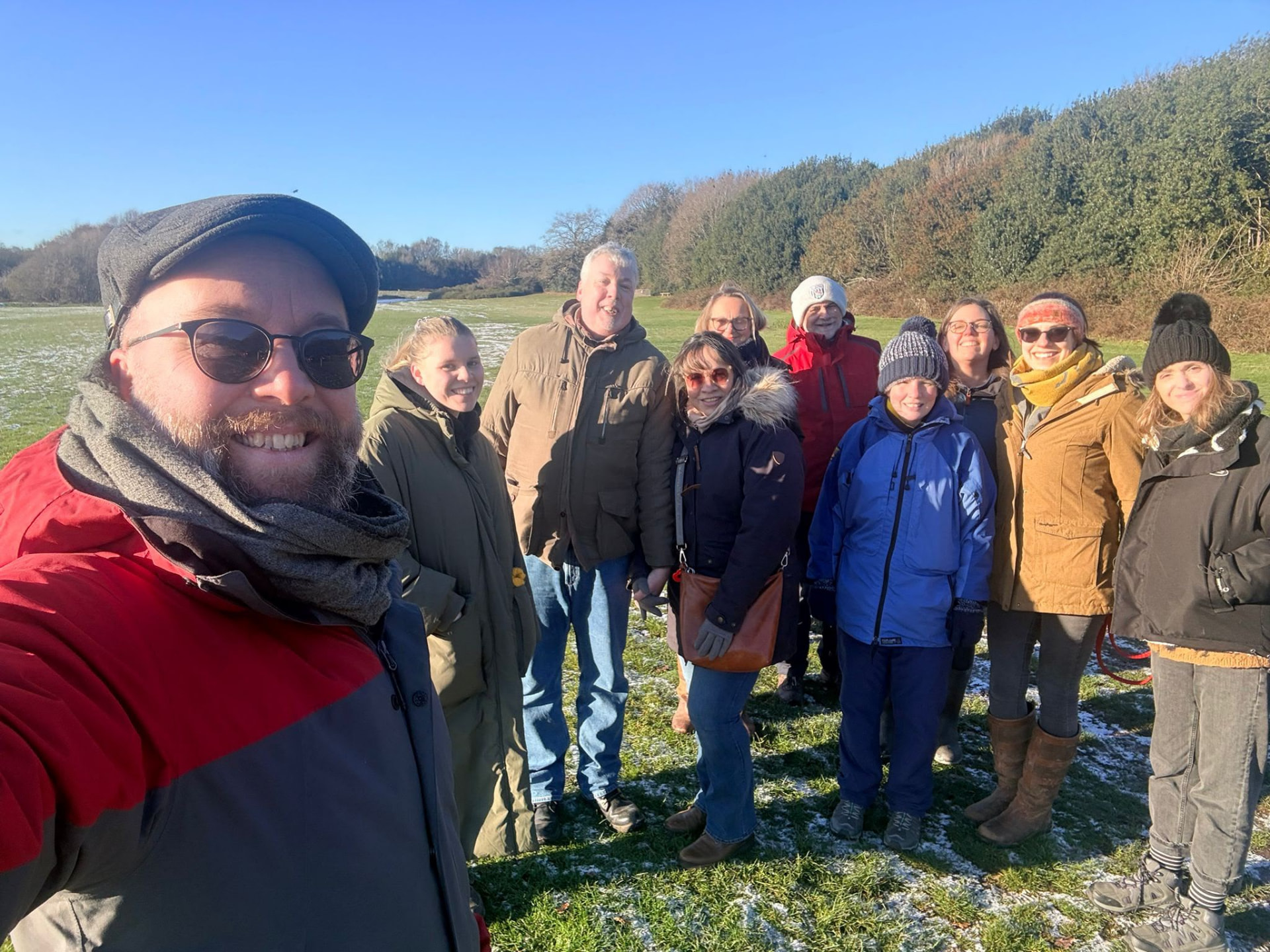 Church walking group gathered in a frosty field on a bright winter morning