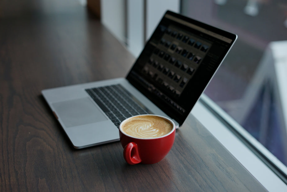 Laptop and coffee cup on a wooden table