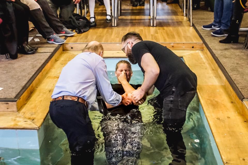 A baptism taking place in the baptistry at Four Oaks Baptist Church