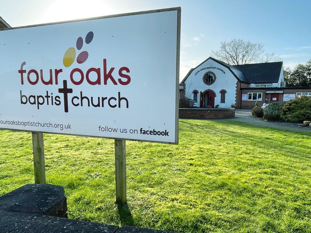 Four Oaks Baptist Church sign on the lawn in front of the church building
