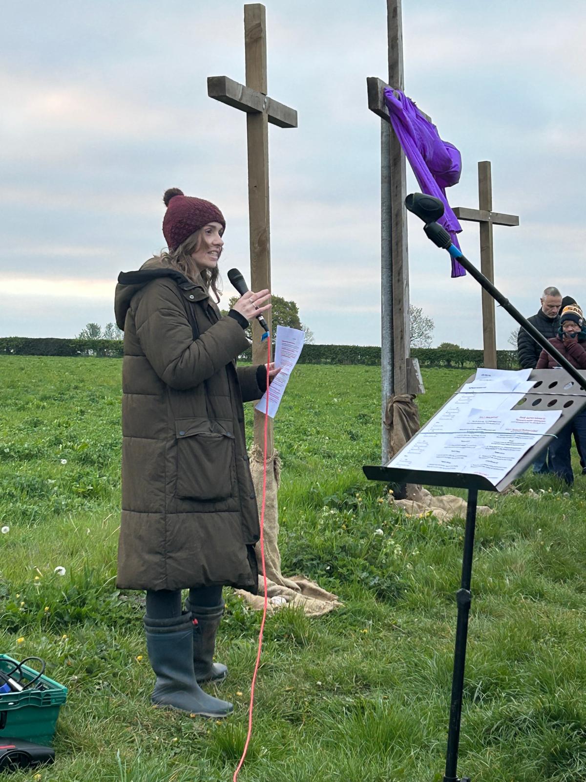 Leading an open-air service beside three wooden crosses