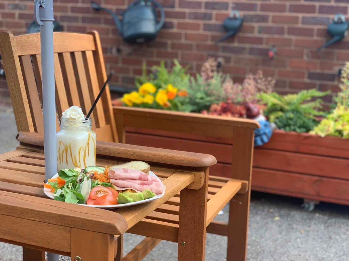 Lunch and a milkshake on a wooden bench in the courtyard