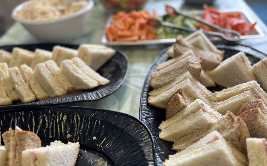 Platters of sandwiches and salads laid out for a church event